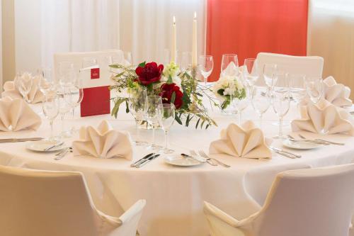 a white table with glasses and flowers on it at Hotel Löwengarten in Speyer