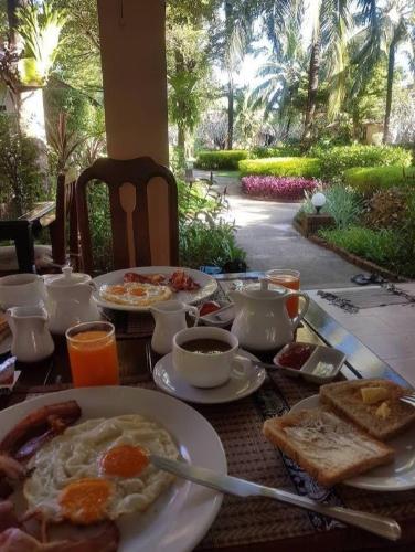 a table with a breakfast of eggs and toast at Jasmin Resort - SHA Plus in Khao Lak