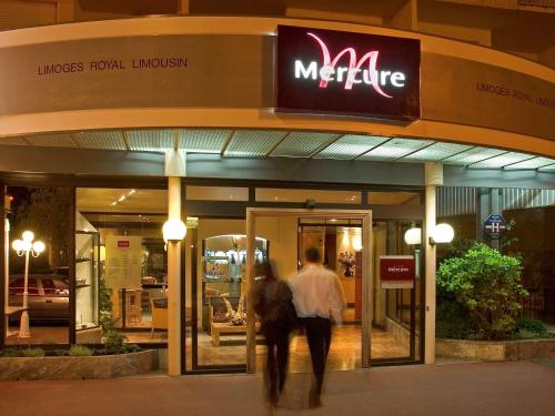 two people walking in front of a store at Mercure Limoges Centre in Limoges