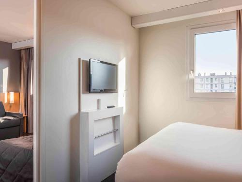 a hotel room with a bed and a television at ibis Le Havre Centre in Le Havre