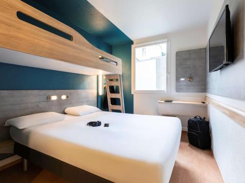 a bedroom with a large white bed and a television at ibis budget Bordeaux Centre - Gare Saint Jean in Bordeaux