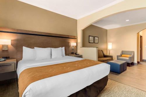 a hotel room with a large bed and a chair at Comfort Suites Baytown I - 10 in Baytown