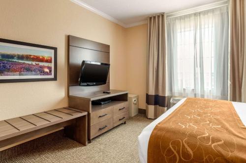 a hotel room with a bed and a flat screen tv at Comfort Suites Baytown I - 10 in Baytown