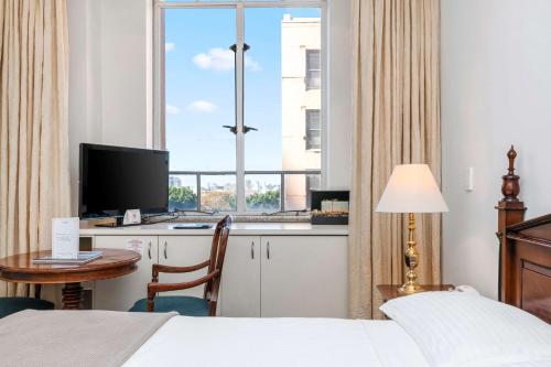 a hotel room with a bed and a desk with a computer at Castlereagh Boutique Hotel, an Ascend Collection Hotel in Sydney
