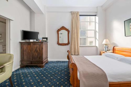 a hotel room with a bed and a mirror at Castlereagh Boutique Hotel, an Ascend Collection Hotel in Sydney