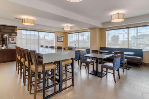 a dining room with tables and chairs and windows at Comfort Suites Baytown I - 10 in Baytown
