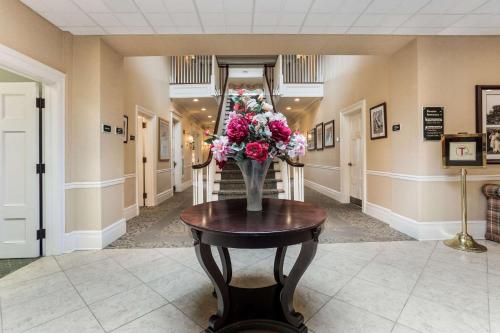 a vase of flowers on a table in a hallway at Traditions Hotel & Spa Johnson City - Binghamton, an Ascend Collection Hotel in Johnson City