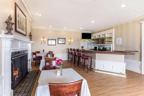 a dining room with a fireplace and a bar at Traditions Hotel & Spa Johnson City - Binghamton, an Ascend Collection Hotel in Johnson City