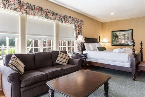 a living room with a couch and a bed at Traditions Hotel & Spa Johnson City - Binghamton, an Ascend Collection Hotel in Johnson City