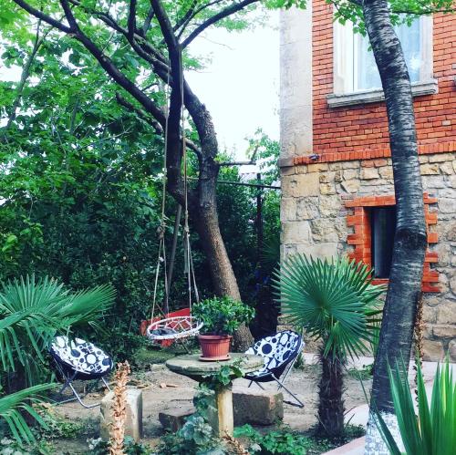 a garden with two chairs and a swing at Guest House Hello in Kutaisi