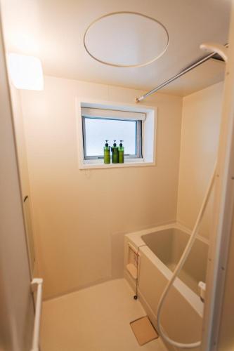 a bathroom with a bath tub and a window at Trailside Apartments Niseko in Kutchan