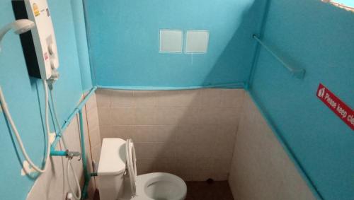 a small bathroom with a toilet and a blue wall at TA YAI HOMESTAY (ตา ยาย โฮมสเตย์) in Ko Kood