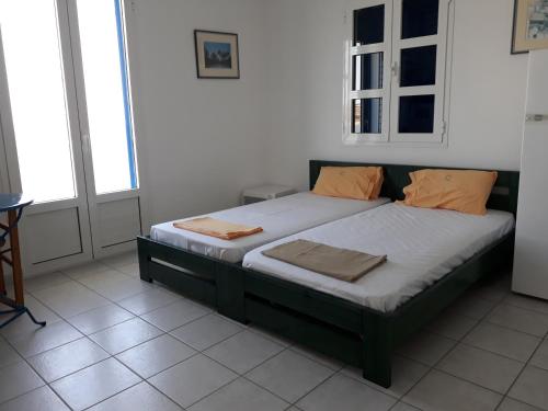 1 dormitorio con 1 cama con almohadas de color naranja en Vivlos. Maisonette with View en Vívlos