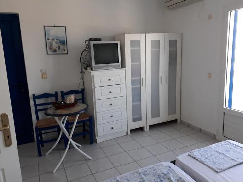 ein Schlafzimmer mit einem TV auf einer Kommode und einem Tisch in der Unterkunft Vivlos. Maisonette with View in Vívlos