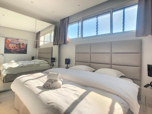 une chambre avec deux lits et une grande fenêtre dans l'établissement 24 Août Sucquet, à Cannes