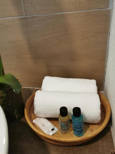 a basket with towels and two bottles of medicine at The Temak Villa in Pantai Cenang