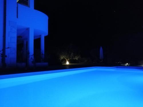 a swimming pool at night with blue lights at Luxury Apartments Klara in Split