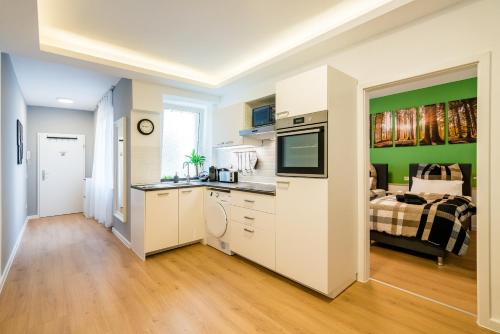 eine Küche und ein Wohnzimmer mit einem Bett im Hintergrund in der Unterkunft Centerapartments Marienstrasse in Düsseldorf