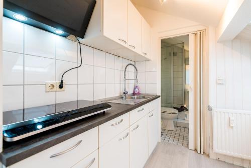 a white kitchen with a sink and a toilet at Centerapartments Tonhallenstraße in Düsseldorf