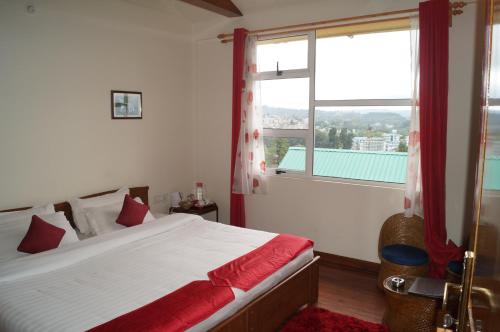 a bedroom with a bed and a large window at Woodland Hill Stay in Shillong