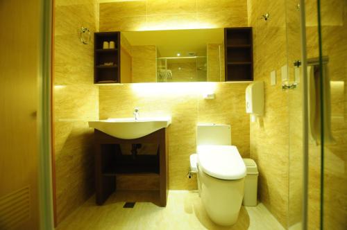 La salle de bains est pourvue de toilettes et d'un lavabo. dans l'établissement Kindness Hotel Hualien, à Hualien