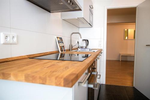 a kitchen with white walls and a wooden counter top at mainhaus Stadthotel Frankfurt in Frankfurt/Main