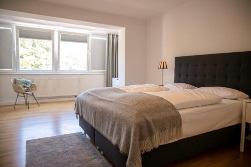 a bedroom with a large bed and two windows at mainhaus Stadthotel Frankfurt in Frankfurt/Main