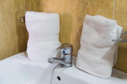 ein Waschbecken mit einem Wasserhahn und zwei Handtüchern darauf in der Unterkunft Apartamentos Los Juncos II in Playa del Ingles