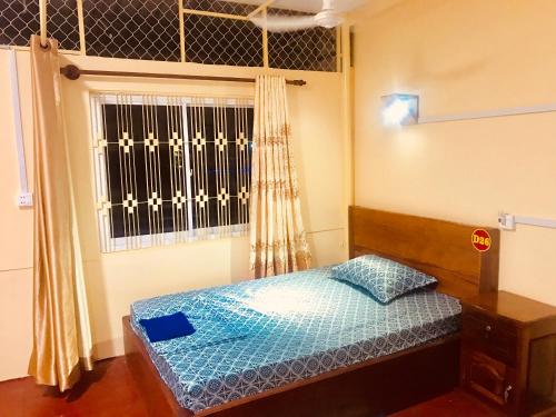 a small bedroom with a bed and a window at Mekong Crossing Guesthouse - Restaurant & Pub in Kampong Cham