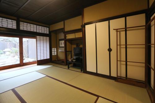 an empty room with a door and a window at Honmachi Juku in Hikone