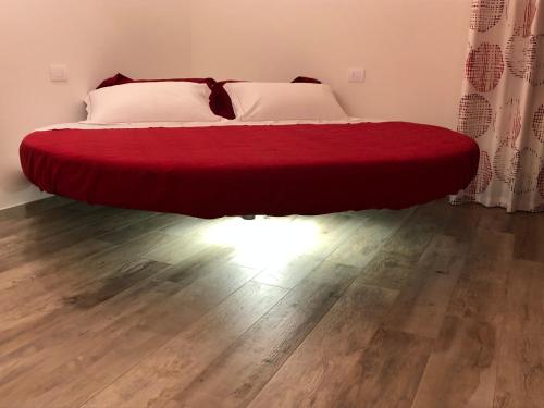 a bed with a red blanket on the floor in a room at Agriturismo N'Uova Campagna in Bologna