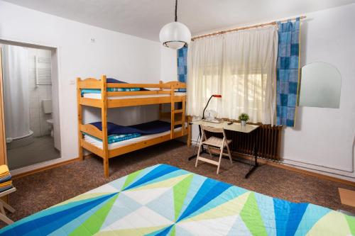 a bedroom with bunk beds and a desk and a bed at Guest House ANA.k in Postojna