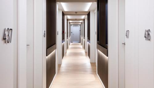 a hallway with white walls and a long corridor with doors at Golden Costa Salou - Adults Only 4* Sup in Salou