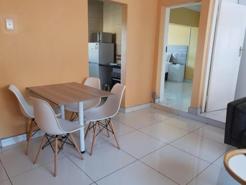 a kitchen and dining room with a table and chairs at LANGA 'S COZY GUESTHOUSE in Pretoria