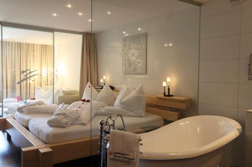 a bathroom with four beds and a bath tub at Wellness Spa Pirmin Zurbriggen in Saas-Almagell