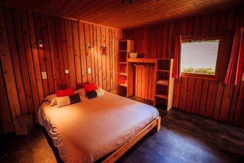 a bedroom with a bed in a wooden room at Les Volca'lodges de Tournebise in Saint-Pierre-le-Chastel