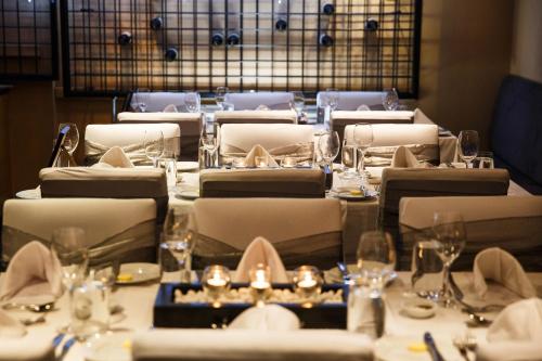 a dining room with tables with chairs and wine glasses at Thredbo Alpine Hotel in Thredbo