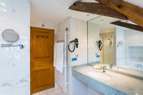 a bathroom with a sink and a mirror at Logis Hôtels Restaurant La Mère Hamard in Semblançay