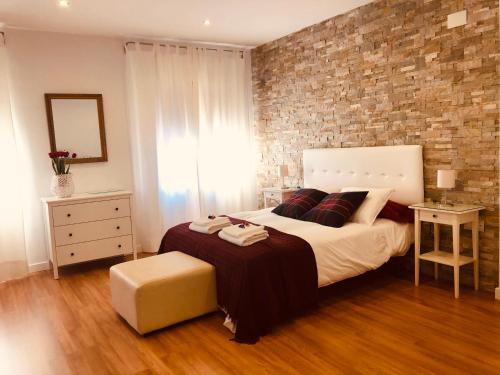 a bedroom with a large bed and a brick wall at LA VICTORIA 1 El Paseo in Archidona