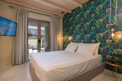 a bedroom with a large bed with a floral wallpaper at Agave Boutique Hotel in Laganas