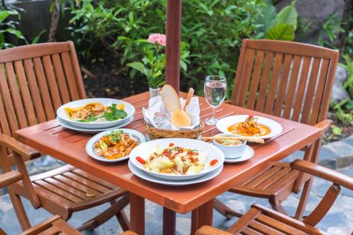 una mesa de madera con platos de comida. en Zenith Sukhumvit Hotel - SHA Extra Plus, en Bangkok