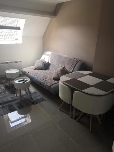 a bedroom with a bed and a table and a window at Cosy village in Bonneuil-en-France