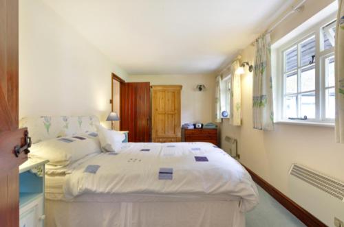 una camera da letto con un grande letto bianco e una finestra di White Lodge House a Guildford