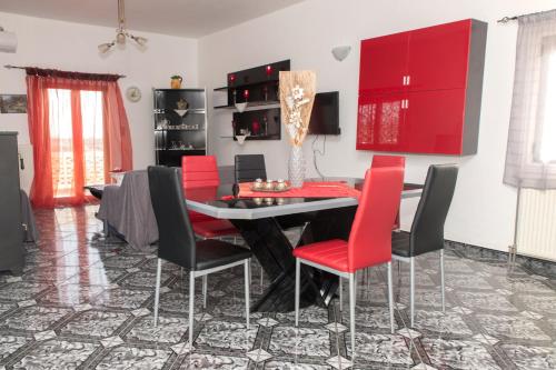 a dining room with red chairs and a black table at Arena's Place in Tympáki