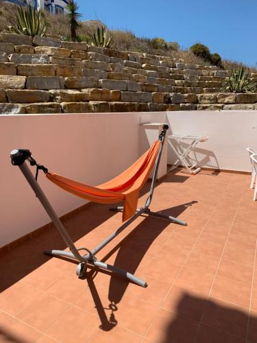 a hammock chair sitting on a patio at Refúgio do Clérigo in Aljezur