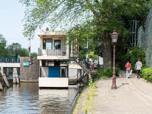 a boat on a river next to a street light at SWEETS - Hortusbrug in Amsterdam