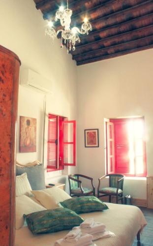 a bedroom with a bed and two chairs and a chandelier at NICOSIA EAGLE EYE in North Nicosia