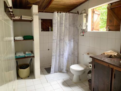 a bathroom with a toilet and a shower curtain at Villa Voanio in Ile aux Nattes