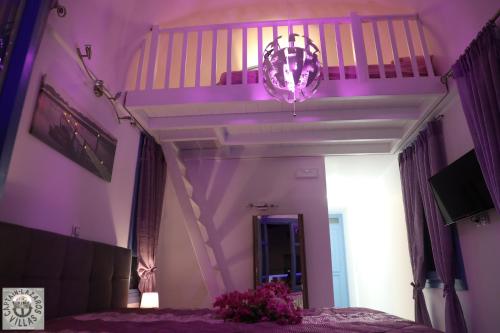 a purple bedroom with a bed and a staircase at Located by the sea one beachfront Private Captain Lazaros Pool Villa with loft in 750sqm spacious private plot-Jacuzzi-sunrelax-furnished terace-gazebo-private parking,sleep 3 adults and 2 children, just steps from the Black Beach-Seaview in Perissa