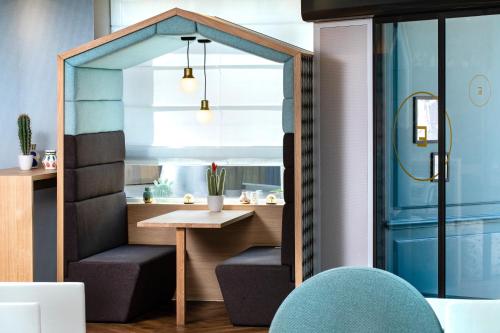 パリにあるHôtel Eiffel Saint Charlesの小さなテーブルと青い椅子が備わる客室です。